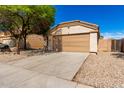 Inviting home featuring a two-car garage, desert landscaping for low upkeep, and modern exterior lighting at 5675 S 239Th Ln, Buckeye, AZ 85326