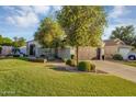 Inviting single-story home with lush green lawn, mature trees, and charming curb appeal at 5711 E Gable Ave, Mesa, AZ 85206