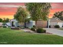 Inviting single-story home with lush green lawn, mature trees, and charming curb appeal at 5711 E Gable Ave, Mesa, AZ 85206