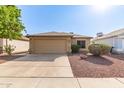 Charming single story home showcasing a two-car garage and low maintenance desert landscaping at 8566 N 110Th Ave, Peoria, AZ 85345