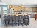 Modern kitchen with a large island, granite countertops, stainless steel appliances and pendant lighting at 10236 W Wood St, Tolleson, AZ 85353