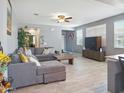 Bright living room featuring a comfortable gray sofa, tile floors, and an entertainment center at 10236 W Wood St, Tolleson, AZ 85353