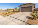 Home featuring a long driveway and a two-car garage, complete with desert landscaping for low maintenance at 12505 W Kaler Dr, Glendale, AZ 85307