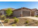 Well-maintained single-story home showcasing desert landscaping, complemented by a two-car garage at 12505 W Kaler Dr, Glendale, AZ 85307