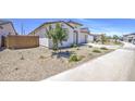 A side view of a single-story home with desert landscaping, shrubs, and a brick fence at 12515 W Marguerite Ave, Avondale, AZ 85323