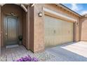 Close up of the entry door, garage door, and a stone-paver sidewalk leading to the entrance at 14075 W Desert Flower Dr, Goodyear, AZ 85395
