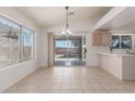 Dining area filled with natural light, tile floors, neutral colors, a bar counter and access to the backyard at 14561 W Winding Trl, Surprise, AZ 85374