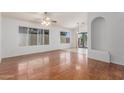 Bright living room featuring hardwood floors, large windows, a ceiling fan, and an elegant decorative alcove at 14561 W Winding Trl, Surprise, AZ 85374