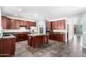 Spacious kitchen featuring stainless steel appliances, dark wood cabinets and a center island at 17853 W Pershing St, Surprise, AZ 85388