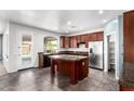 Spacious kitchen featuring stainless steel appliances, dark wood cabinets and a center island at 17853 W Pershing St, Surprise, AZ 85388