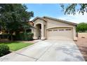 Well-maintained single-story home showcasing a tidy lawn, established shrubbery and two-car garage at 2727 S 160 Ln, Goodyear, AZ 85338