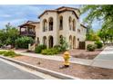 A two-story home with arches, balconies, and verdant landscaping at 2854 N Claire Dr, Buckeye, AZ 85396