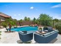 Beautiful pool area with outdoor seating, perfect for relaxing and entertaining guests at 31221 N 130Th Ln, Peoria, AZ 85383
