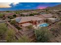 An aerial view showcases the beautiful home, pool, and mountain views at 42101 N Olympic Fields Ct, Anthem, AZ 85086