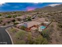 An aerial view showcases the beautiful home, pool, and mountain views at 42101 N Olympic Fields Ct, Anthem, AZ 85086