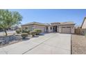 Well-kept single-story home with tandem three-car garage and a mature mesquite tree in front at 43205 W Oster Dr, Maricopa, AZ 85138