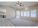 Spacious living room with carpet, tile flooring, and large windows providing plenty of natural light at 43205 W Oster Dr, Maricopa, AZ 85138