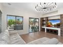 Bright living room with hardwood floors, a stone entertainment center, and sliding doors leading to the backyard at 4960 E Colonial Dr, Chandler, AZ 85249