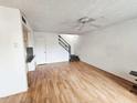 Bright living room with laminate floors, ceiling fan, and staircase at 5446 W Sheena Dr, Glendale, AZ 85306