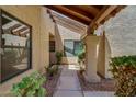 Close-up of a covered walkway featuring desert landscaping, decorative pillars, and textured walls at 713 W Boxelder Pl, Chandler, AZ 85225