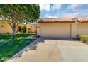 Charming home featuring a two-car garage, tile roof, and lush lawn with a mature tree in the front yard at 713 W Boxelder Pl, Chandler, AZ 85225