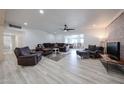 Spacious living room featuring modern flooring, a brick accent wall, and comfortable seating at 7201 N 16Th Dr, Phoenix, AZ 85021