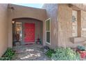 Close-up of the front entrance, showcasing a red door and decorative landscaping at 7302 E Rose Ln, Scottsdale, AZ 85250