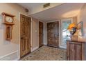 Hallway featuring wood doors, neutral paint, and a decorative rug at 7302 E Rose Ln, Scottsdale, AZ 85250