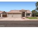 Inviting home featuring a three-car garage, tile roof, and professionally landscaped yard at 7344 E Flower Ave, Mesa, AZ 85208