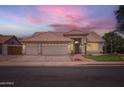 Inviting home featuring a three-car garage, tile roof, and professionally landscaped yard at 7344 E Flower Ave, Mesa, AZ 85208