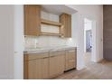 Kitchenette with wooden cabinets, marble countertops and backsplash, and stylish lighting at 1538 W Wagon Wheel Dr, Phoenix, AZ 85021