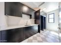 Sleek kitchen with dark cabinetry, white countertops, and stainless steel sink at 1538 W Wagon Wheel Dr, Phoenix, AZ 85021