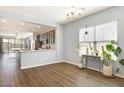 Bright dining area with hardwood floors, large windows, and a view of the open kitchen at 19664 W Woodlands Ave, Buckeye, AZ 85326