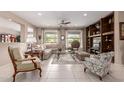 Bright living room featuring neutral decor, tile floors, large windows with views, and a built-in media center at 19722 N Regents Park Dr, Surprise, AZ 85387