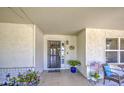 Inviting front porch featuring neutral colors, a security screen door, and cozy seating area at 2046 E Downing St, Mesa, AZ 85213