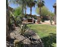 Lush backyard featuring a well-manicured lawn, desert landscaping, and cozy seating, ideal for relaxation at 30178 N Coral Bean Dr, San Tan Valley, AZ 85143