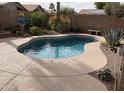 Inviting backyard pool surrounded by desert landscaping and a large deck, perfect for outdoor entertainment at 30178 N Coral Bean Dr, San Tan Valley, AZ 85143