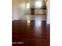 Open living space with view to the kitchen and beautiful dark hardwood flooring at 3404 W Tangerine Ln, Phoenix, AZ 85051