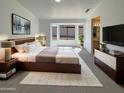 Cozy bedroom featuring a bay window, ensuite bathroom, and a modern bed frame at 3407 N 67Th Ln, Phoenix, AZ 85033