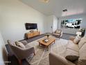 Bright living room with a large front window, cozy seating, and a stylish rug at 3407 N 67Th Ln, Phoenix, AZ 85033