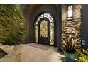 Elegant arched front door with decorative ironwork and stone accents at 36133 N 24Th Ave, Phoenix, AZ 85086