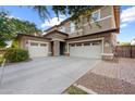 Beautiful two-story home with a three-car garage, appealing stone accents, and modern lighting fixtures at 3822 E Amber Ln, Gilbert, AZ 85296