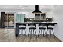 Modern kitchen features white cabinets, stainless steel appliances, black countertops, and bar stool seating at 5728 E Sharon Dr, Scottsdale, AZ 85254