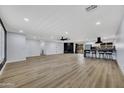 Large living room with wood flooring, fireplace, and open access to the modern kitchen at 5728 E Sharon Dr, Scottsdale, AZ 85254