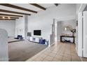 Bright living room with a vaulted ceiling, beams, and a combination of carpet and tile flooring at 8034 E Del Caverna Dr, Scottsdale, AZ 85258