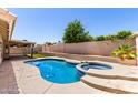 Relaxing backyard featuring a sparkling pool, spa, and desert landscaping at 8500 W Saint John Rd, Peoria, AZ 85382