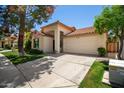 Inviting single-story home with a two-car garage, arched entryway, and well-maintained lawn and landscaping at 9575 S Ash Ave, Tempe, AZ 85284