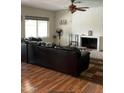Cozy living room featuring a fireplace, ceiling fan, and hardwood floors at 11640 N 74Th Dr, Peoria, AZ 85345