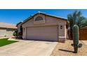 Single-story home with a desert landscape, two-car garage, and a mature saguaro cactus at 15231 W Melissa Ln, Surprise, AZ 85374