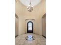 Grand foyer with soaring ceiling, designer chandelier, arched doorways and decorative tile design at 18036 W San Miguel Ave, Litchfield Park, AZ 85340